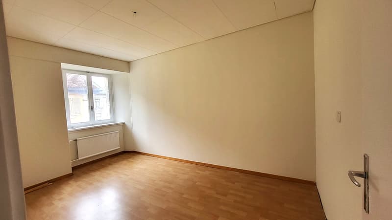 Empty room, white walls, wooden floor, window with white shutter