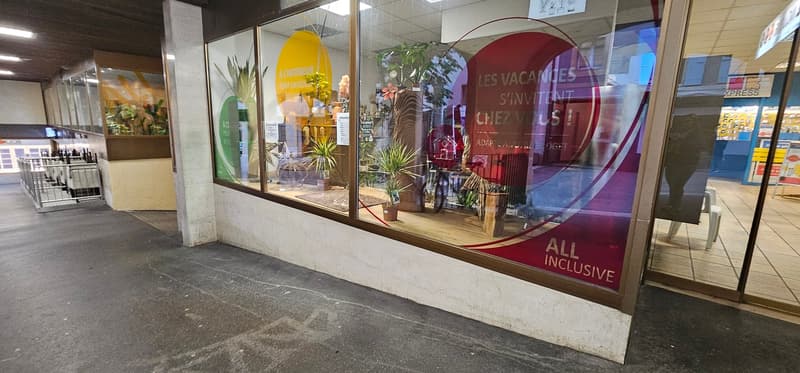 Shop with glass front display and various plants visible inside.