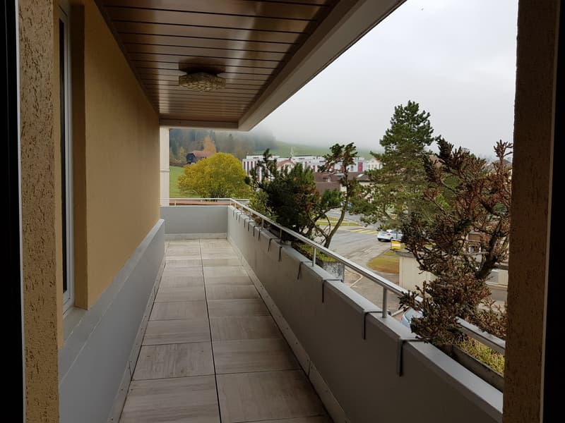 large balcony, tiled floor, metal railing, views of green landscape
