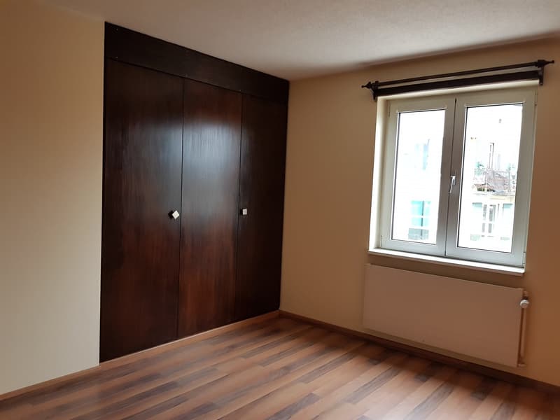 wooden floor, wooden wardrobe, white radiator, window