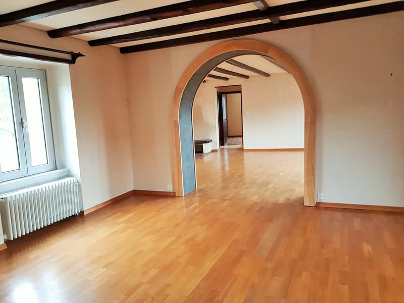 wooden floor, wooden ceiling, arched entrance, white walls, glass windows, heater, arched doorway