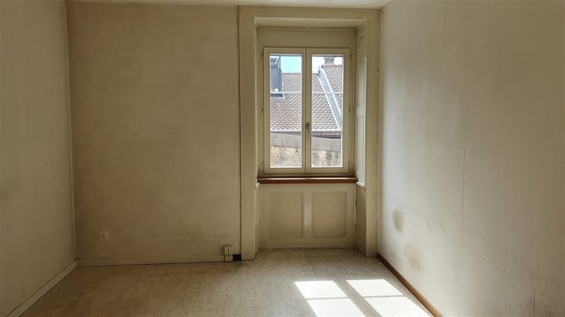 empty room with white walls, floor and ceiling, large window, power outlet, white painted window sill