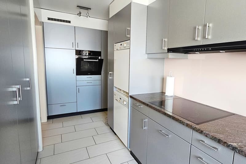 Modern kitchen, tiled floor, gas stove, white appliances, oven, extractor hood, gray cabinets