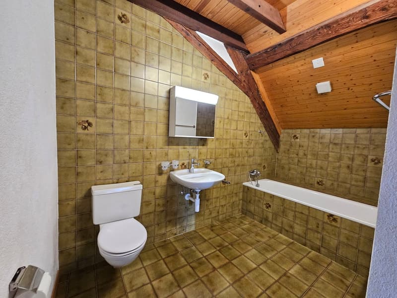 Bathroom with toilet, sink, bathtub, wooden ceiling, tiled walls