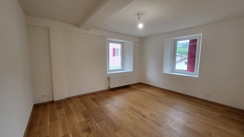 empty room, wooden floor, white walls, two windows, radiator