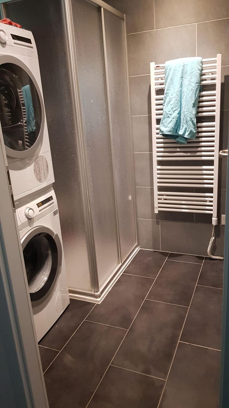 Large laundry room, washing machine, dryer, shower stall, radiator, towel rack, tiled floor
