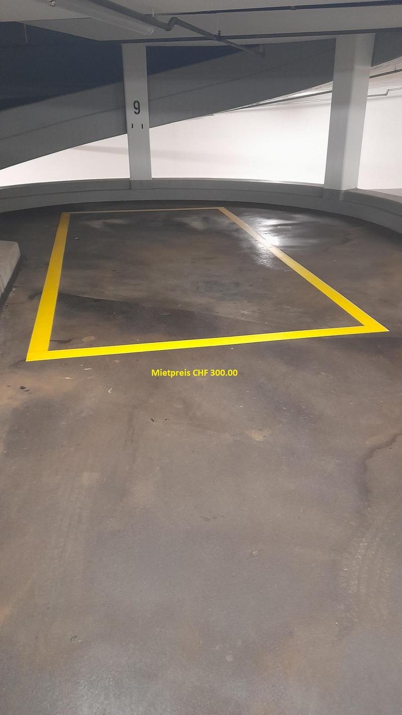 Parking space number 9, yellow lines, concrete floor, empty