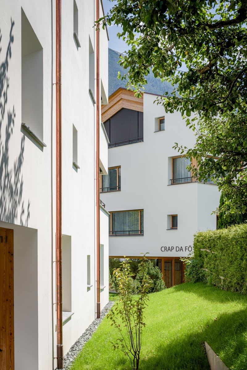 white exterior, copper pipes, raised ground floor, several balconies
