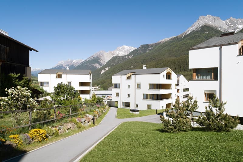 white residential buildings, raised ground floor, balconies, garden, pathway