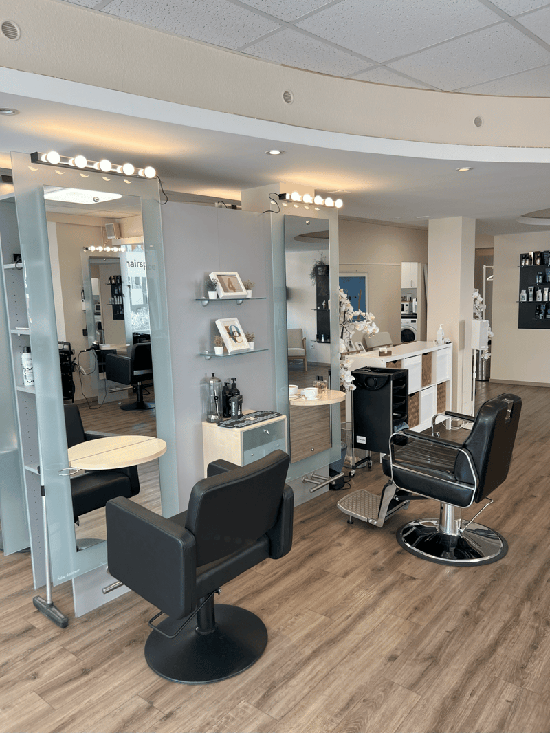 {"type": "Salon","visible_features": [],"description": "Interior of a salon with black leather chairs, wooden floors, mirrors, tables, cabinets, and various salon equipment.","localized_descriptions":    {    "EN": "Interior of a salon with black lea