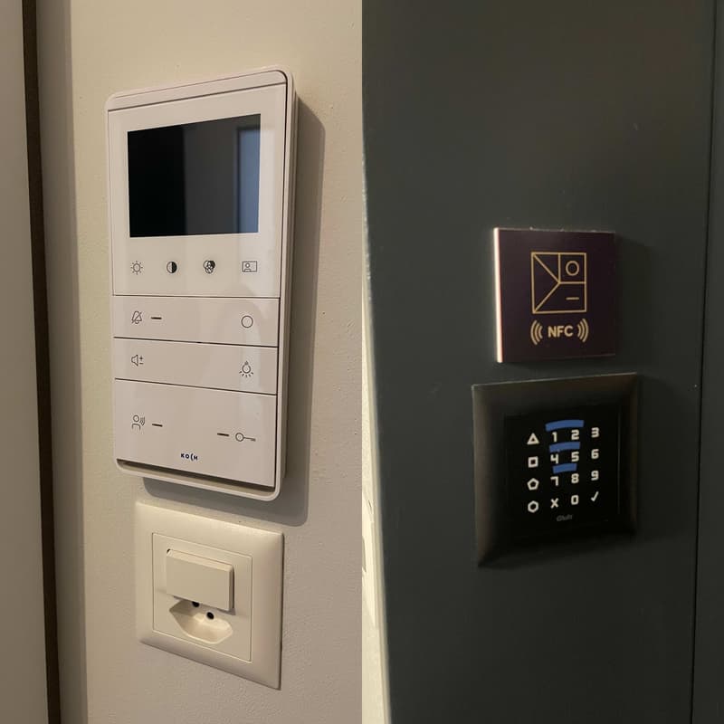 White wall with an electric outlet with a switch, touchpad, and NFC access.