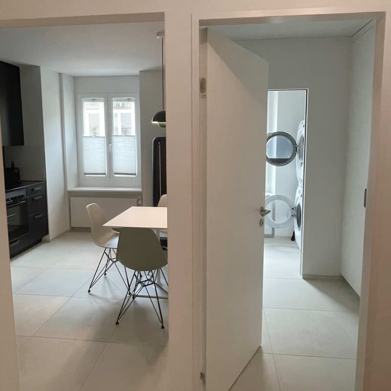 dining area with white table, chairs, kitchen, laundry room with washing machine