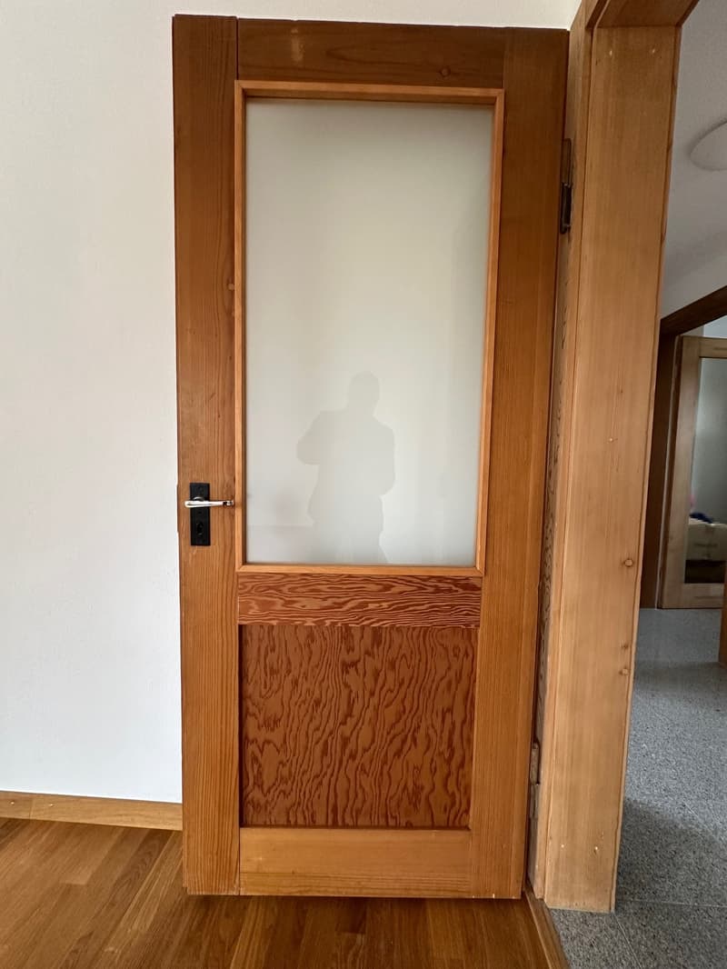 Wooden door with a glass panel, wooden frame and trim, hardwood floor