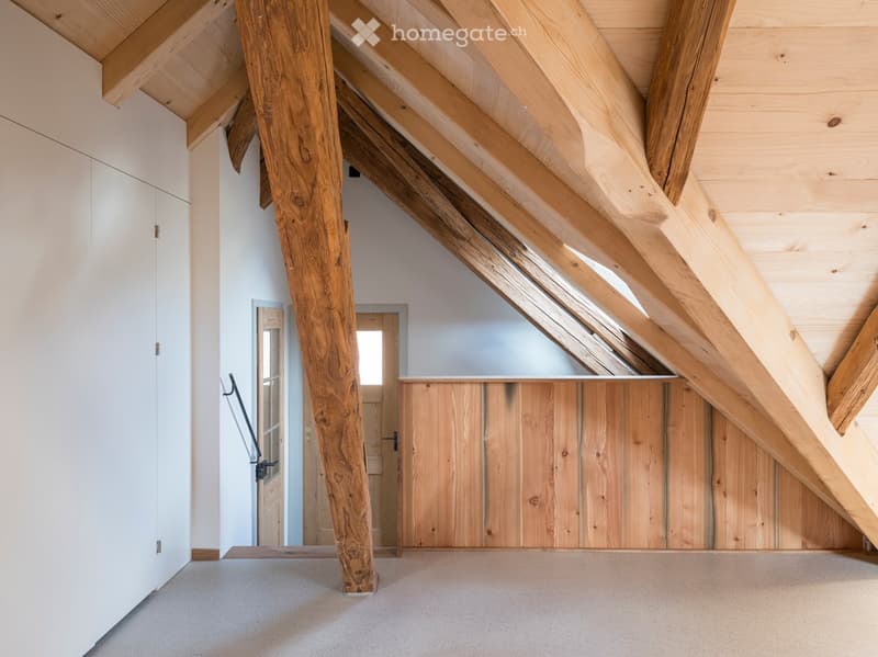 ample wooden beams, wooden ceiling, white walls, wooden floor, a window