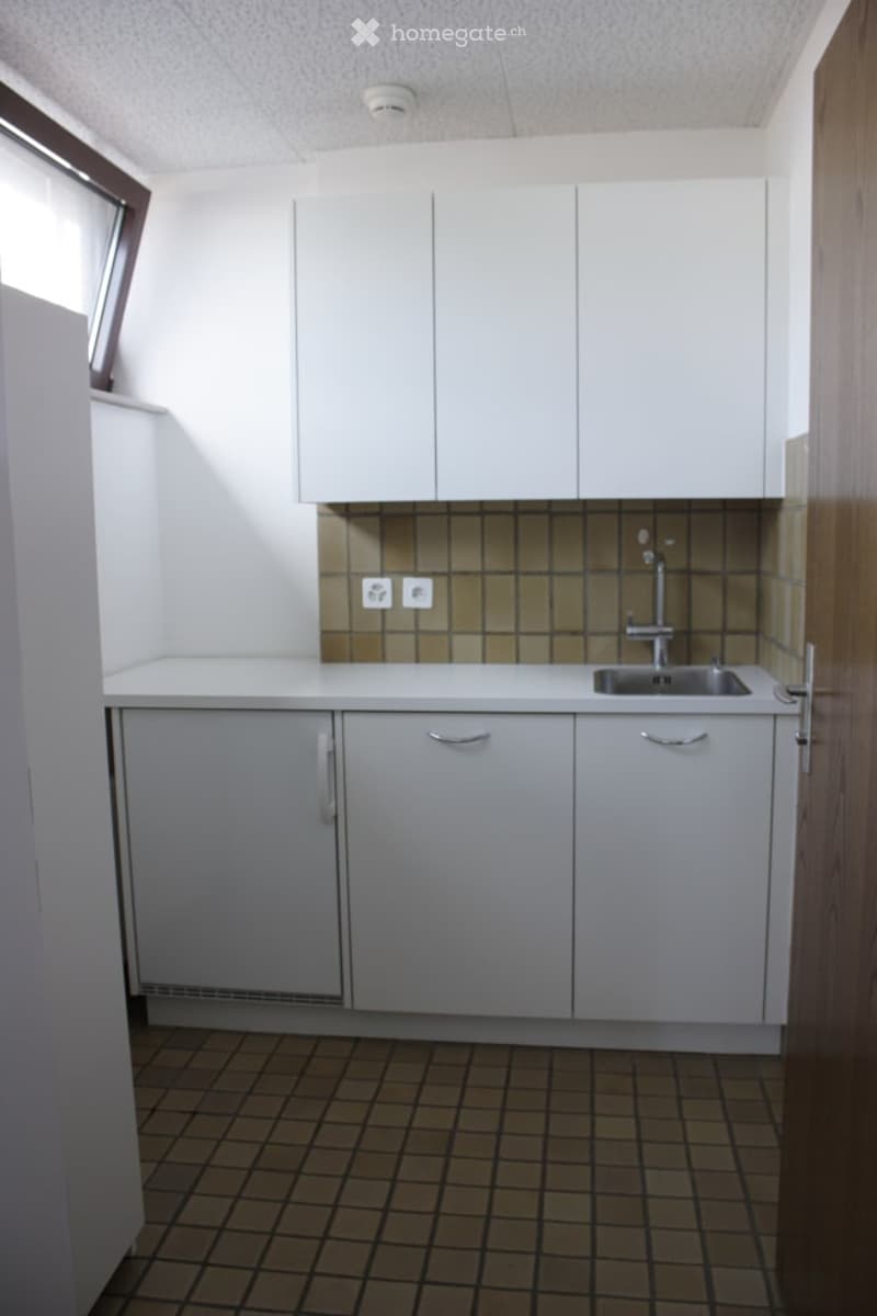 White cabinets, tile backsplash, sink, and a washing machine