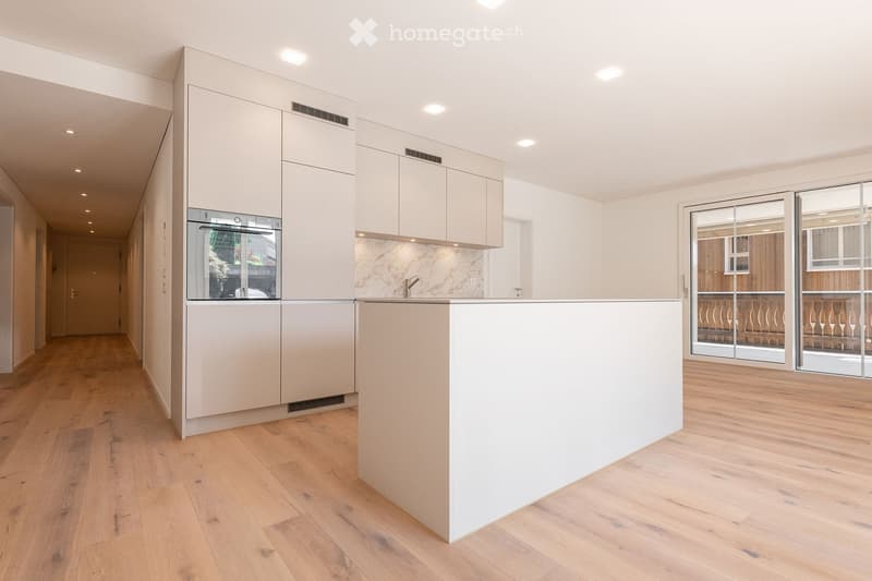 modern kitchen, white cabinets, marble countertop, stainless steel oven, island, hardwood floors, sliding glass doors to balcony