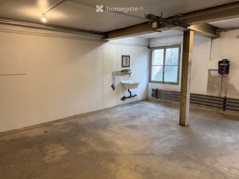 empty, white walls, concrete floor, a sink, pipes, window, heating system