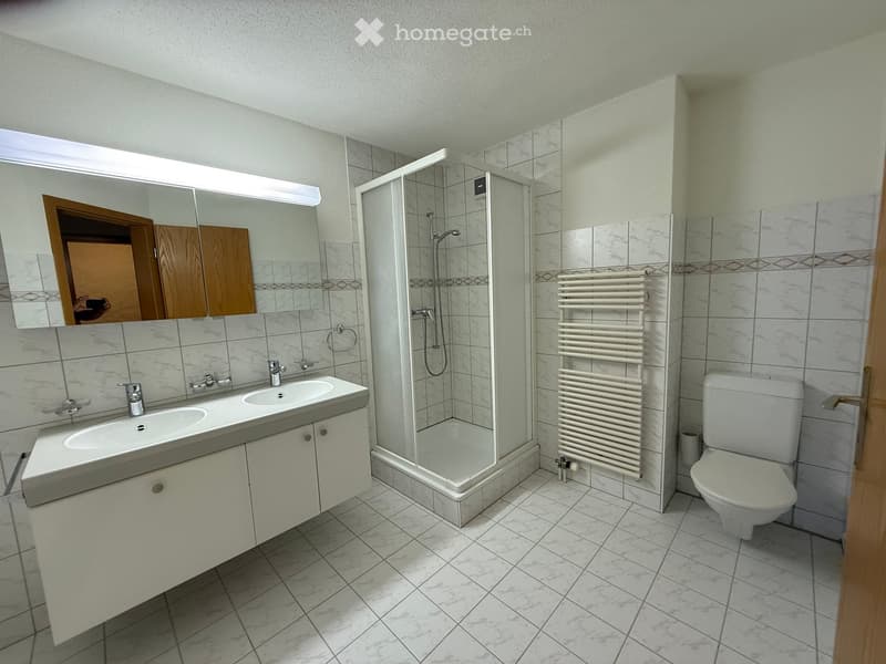 Double sink vanity, modern shower with glass door, underfloor heating, large mirror, white tiles