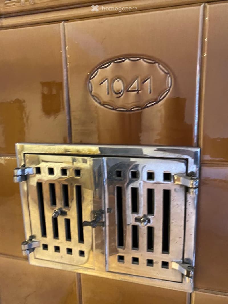 Bronze color tiled background, silver metal grate, circular number plate reading 1041