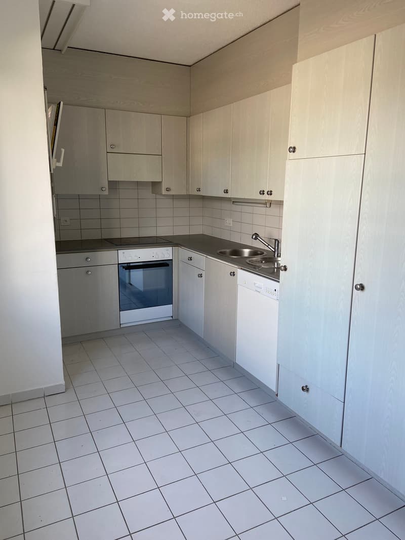 Open kitchen with white tiled floor, white cabinets, double sink, gas stove, oven, dishwasher, power outlets, white light fixture