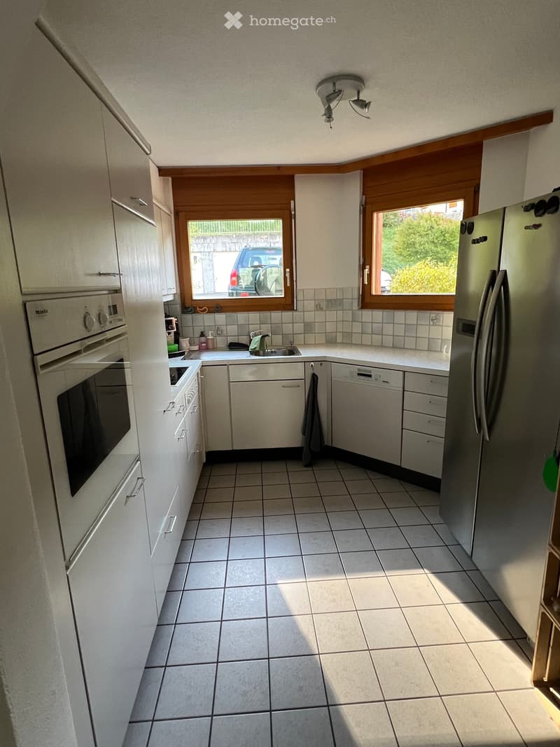 modern kitchen, white cabinets, granite countertops, integrated dishwasher, microwave, oven, fridge, tiled flooring, large window with view to outside, double sink with faucet, ceiling lights