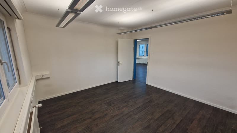wooden floor, white walls, window, fluorescent lighting, open door