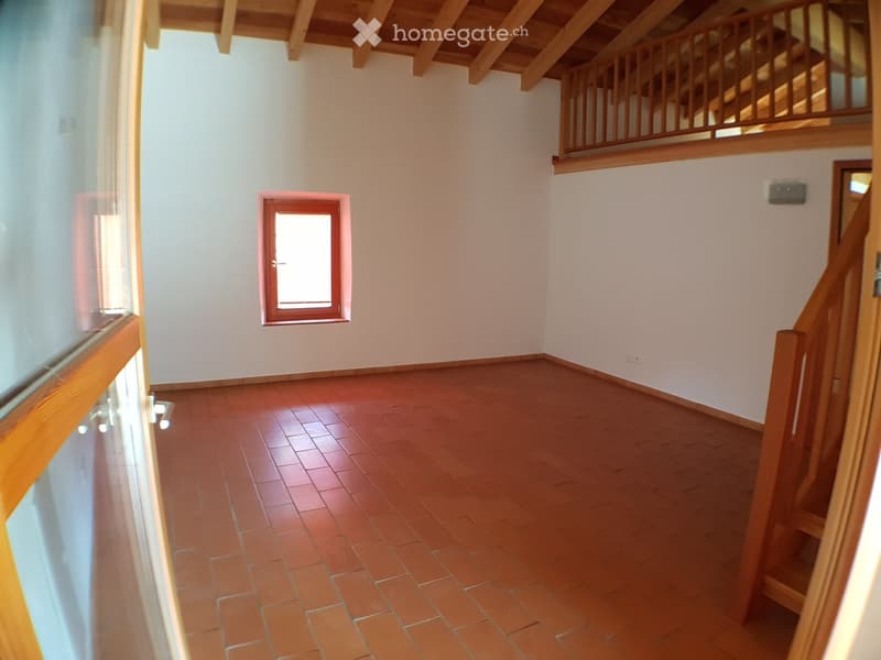 empty room with wooden flooring, small window, stairs leading to upper floor