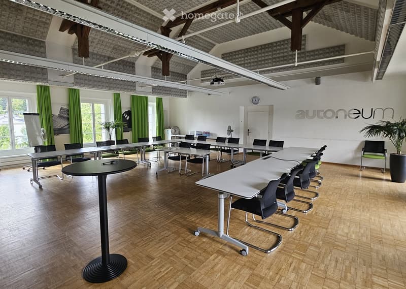conference room with several tables, chairs, a projector screen, and a projector