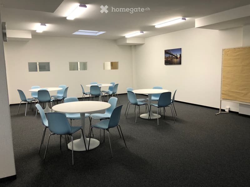 White walls, circular tables, chairs, picture, white floor lighting