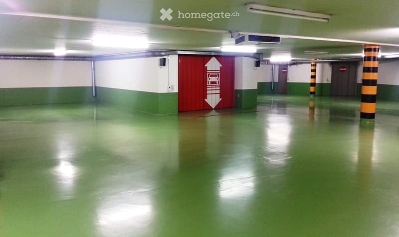 An empty parking lot with a red door indicating a loading area
