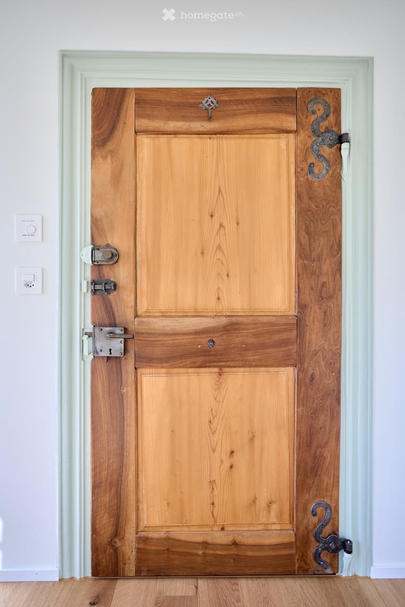 Wooden door with white wall, mint trim, 3 locks and hinges.