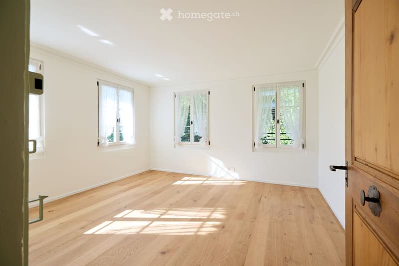 empty room, hardwood floor, white walls, three windows, wooden door
