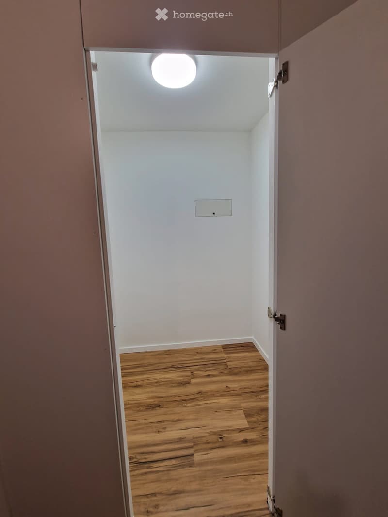 Empty room with wooden floor and white walls.