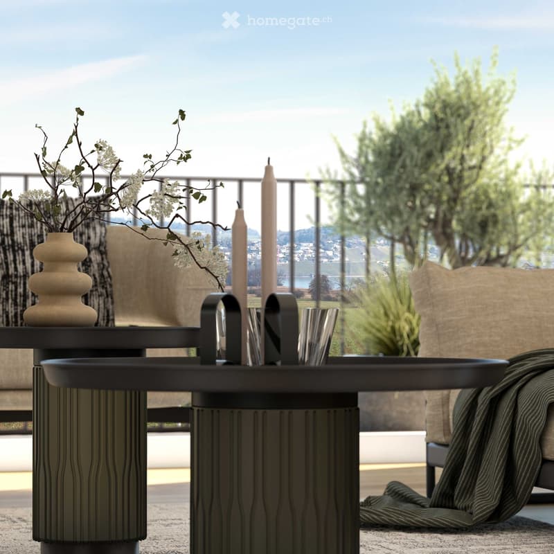 Balcony with table, vase with branches, windows with metal grills, distant buildings and water, floor-to-ceiling windows