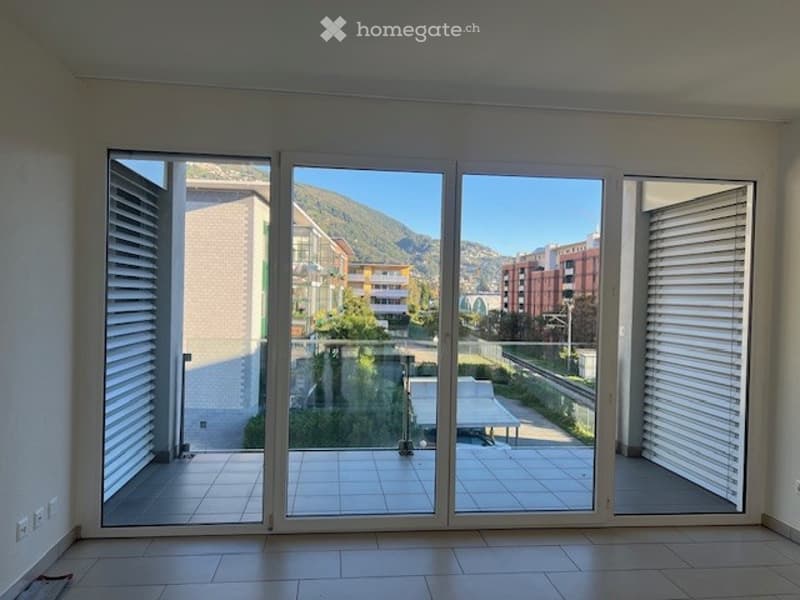 Large sliding glass doors, tiled floor, view of mountains and buildings, balcony