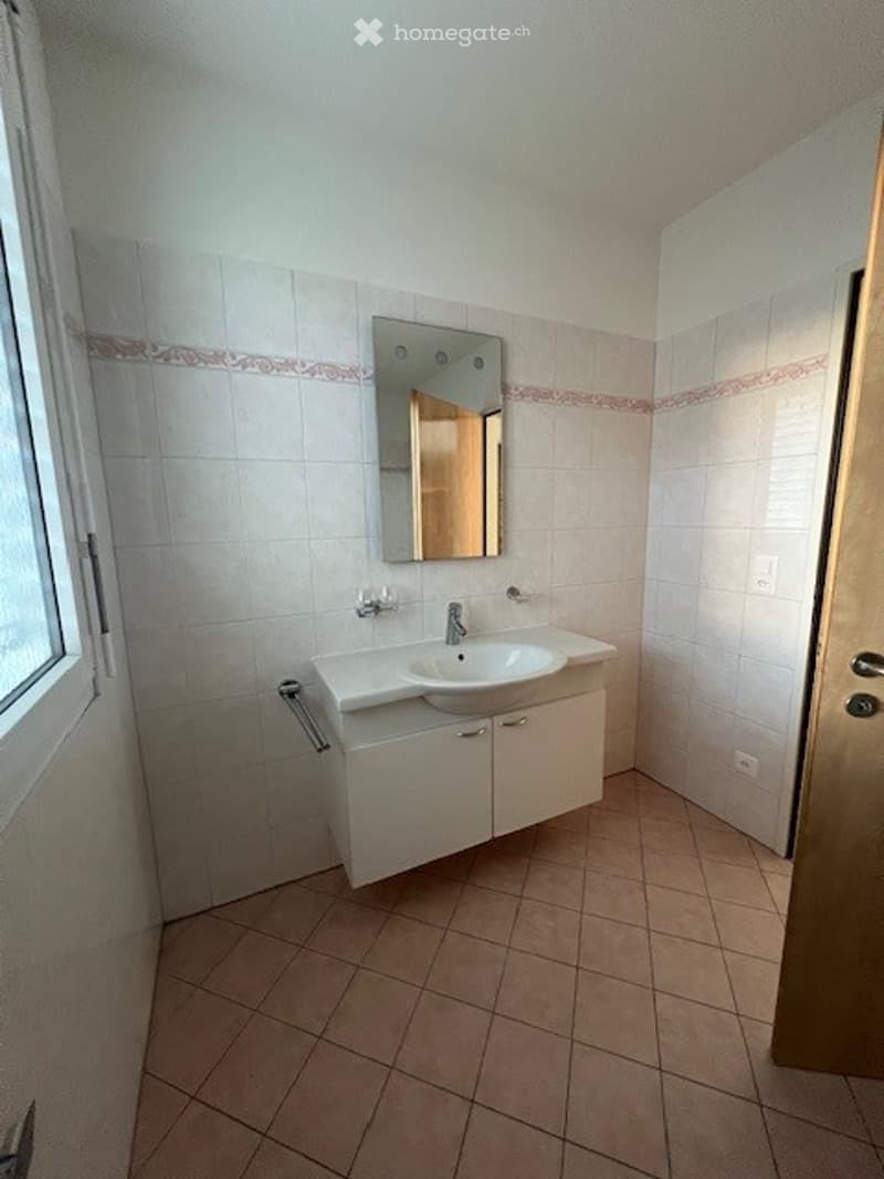 Bathroom: white tiles, white cabinet, sink, mirror, tiled floor