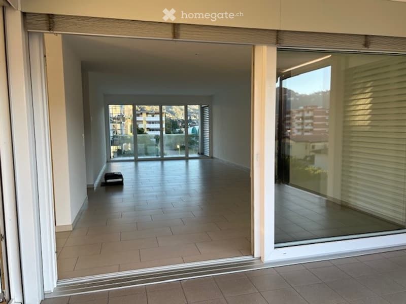 open room with large windows, terrace, tiled floor, glass doors
