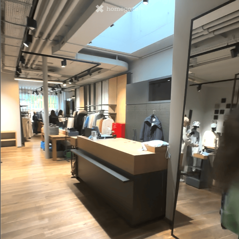interior of a clothing store, hardwood floor, front desk, mannequins, clothing racks