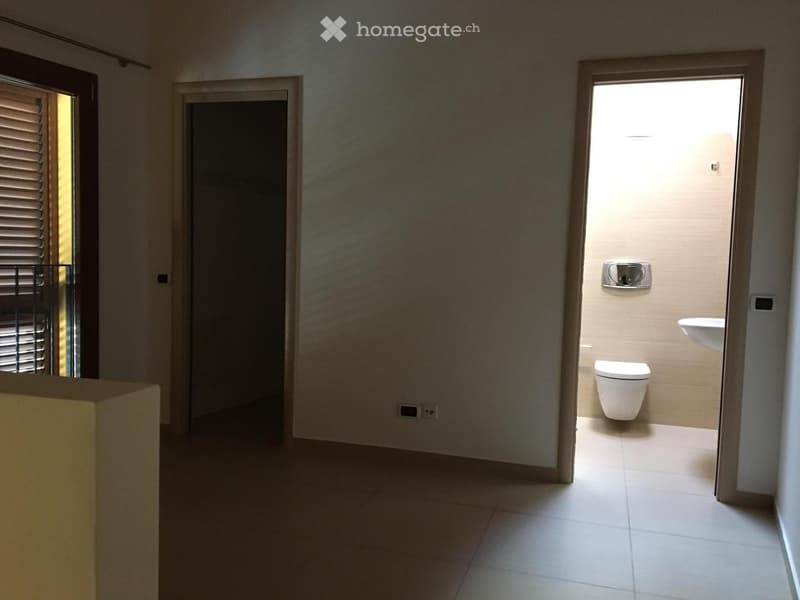 White tiled floor, bathroom with toilet and sink, power outlet, window with blinds, balcony