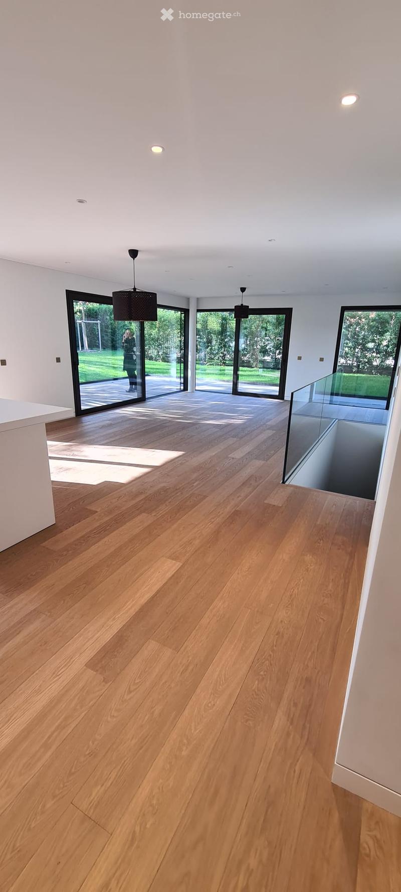 hardwood floor, glass doors, high ceiling, white walls, two lamps