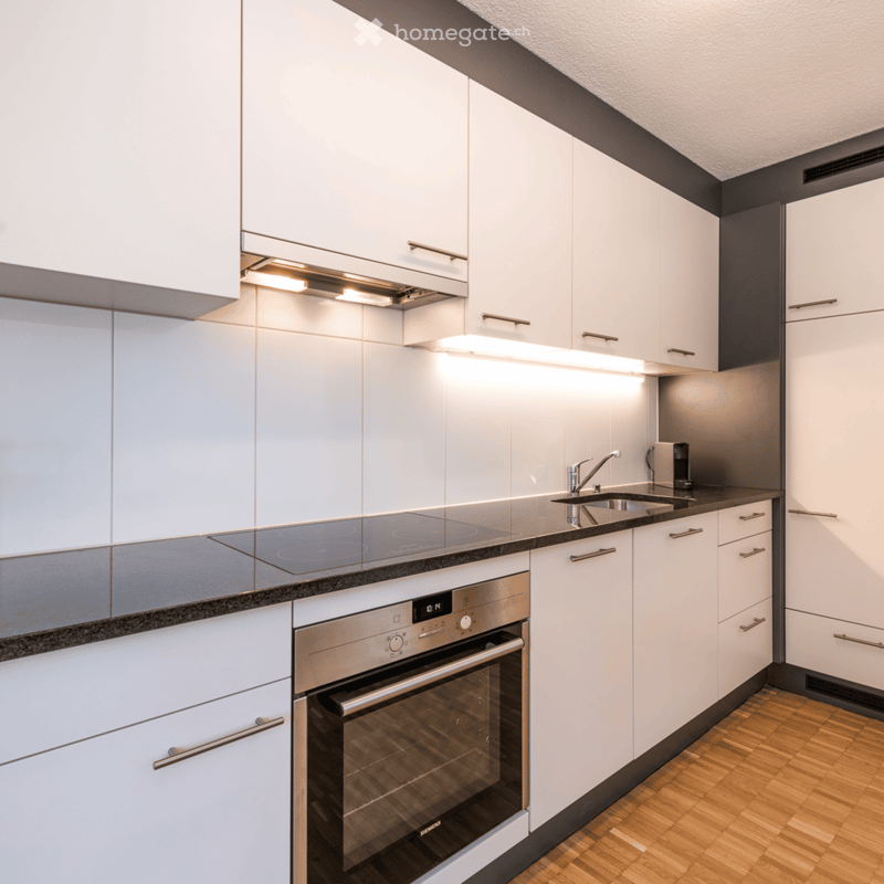 modern kitchen with wooden floor, all white cabinets, stainless steel oven, kitchen sink, granite countertop
