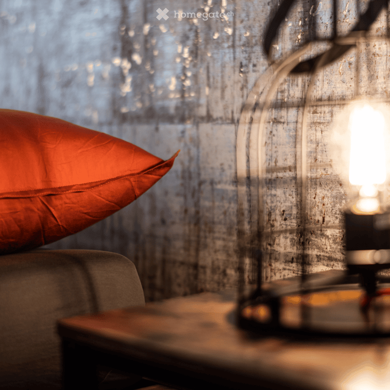 modern gray sofa with red pillow, metal table with lamp