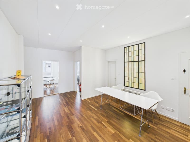 open room, hardwood floor, white walls, white table, white chairs, glass display case, colorful window