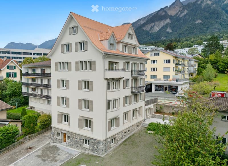 modern 6 story apartment building, beige color, brown roof, windows with gray shutters, multiple balconies