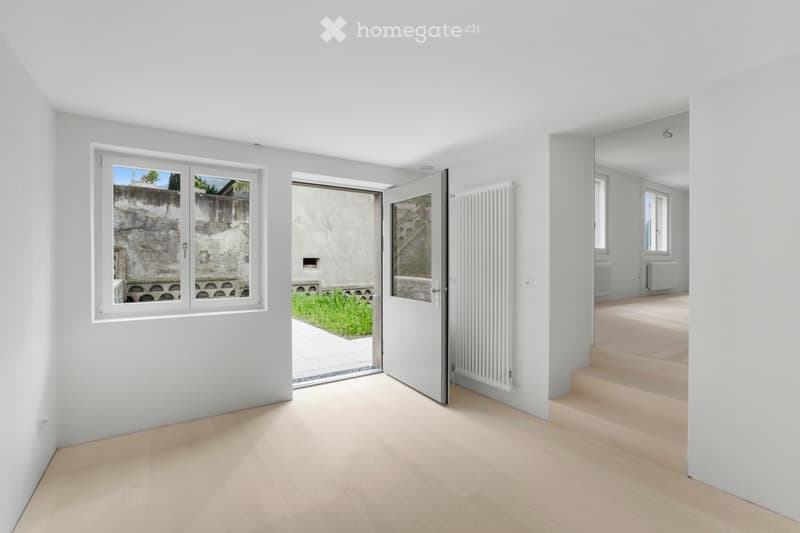 empty room, white walls, large windows, wooden floors, radiator, white door, outdoor view