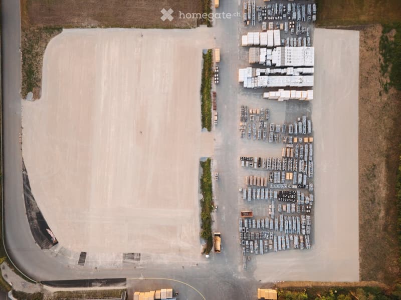 large parking lot, gravel surface, neatly arranged storage boxes