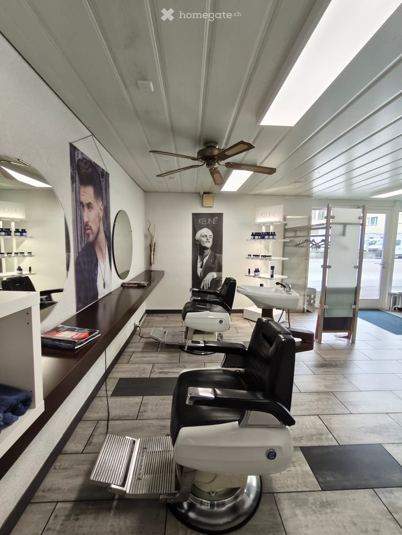 a barbershop with chairs, mirrors, and shelves with bottles