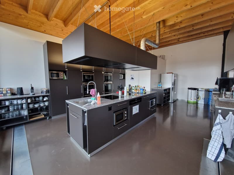 modern kitchen with black countertops, modern appliances, wooden ceiling, open plan