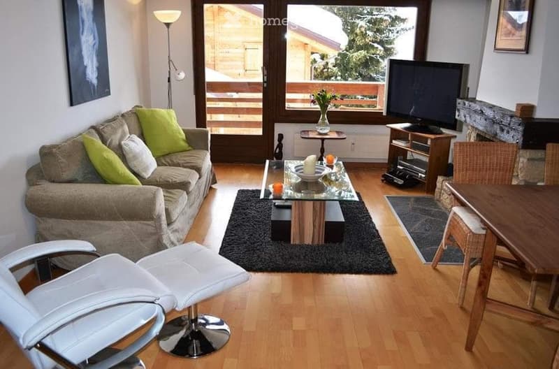 leather sofa, cushions, glass coffee table, wooden table, dining chairs, glass door to balcony, fireplace, television, lamp