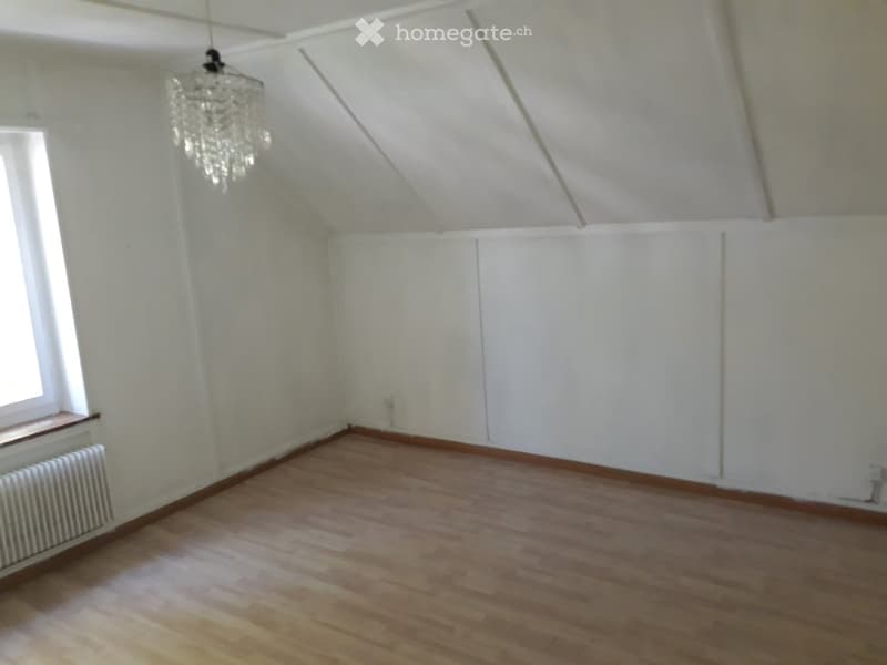 white walls, wooden floor, chandelier, window, radiator